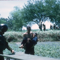 Stretcher waiting for hurt civilian (chopper landed in flooded rice paddy)