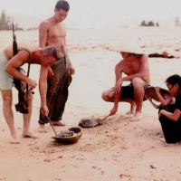 S/Sgt. John Snyder holding M 14 plays with Horse Shoe Crab at Chu Lai Aug. 1965