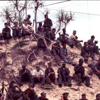 Marines sit on sand dune as they watch USO show at Chu Lai Aug. 1965